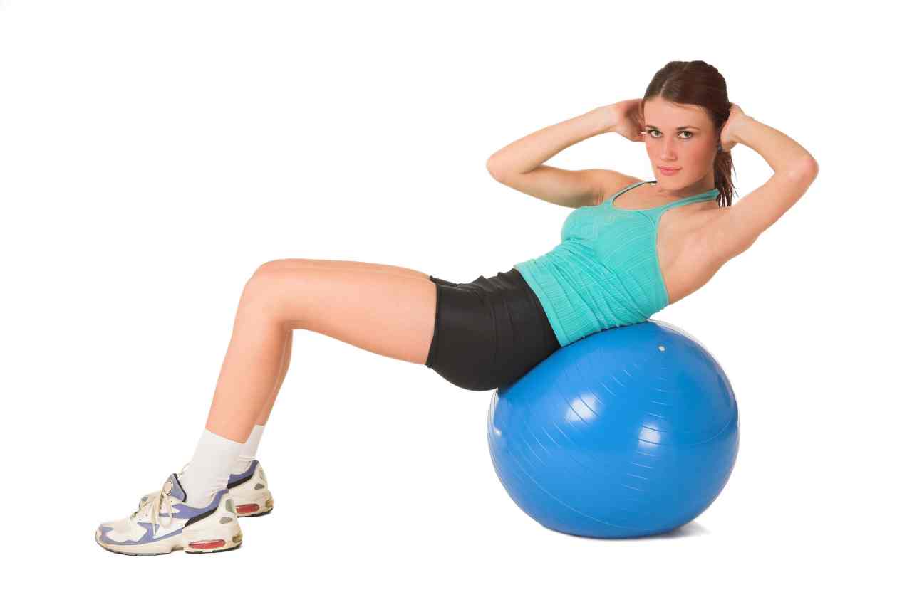 Woman working out on blue ball.
